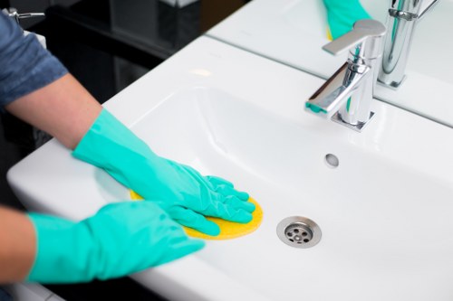 Cleaner tidying a kitchen during domestic cleaning in Putney